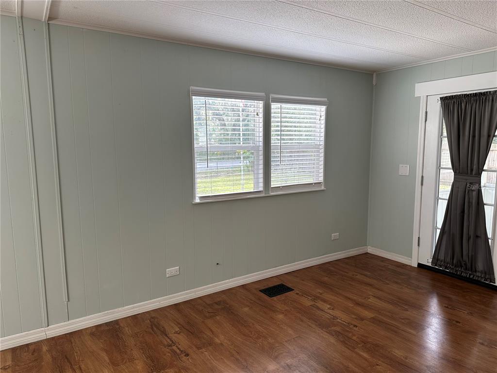 24007 River Road Astor, FL 32102 - Photo 9 of 37 an empty room with wooden floor and a window