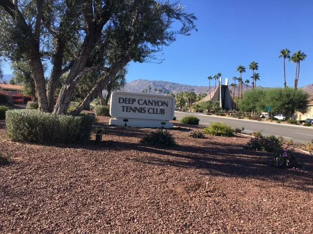 a sign board with a bench in the background