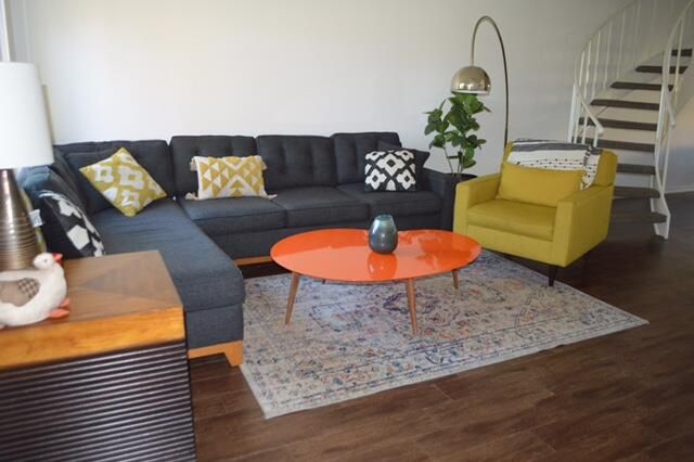 a living room with furniture and a wooden floor