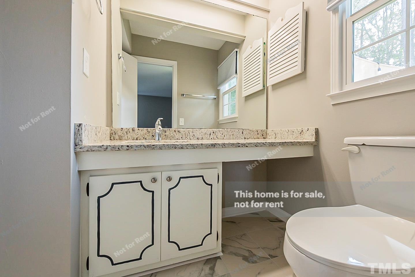 1338 Sedwick Road Durham, NC 27713 - Photo 17 of 20 a bathroom with a toilet sink and mirror