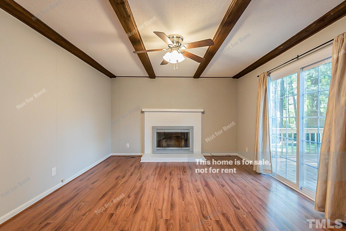 1338 Sedwick Road Durham, NC 27713 - Photo 3 of 20 a view of an empty room with wooden floor fireplace and a window