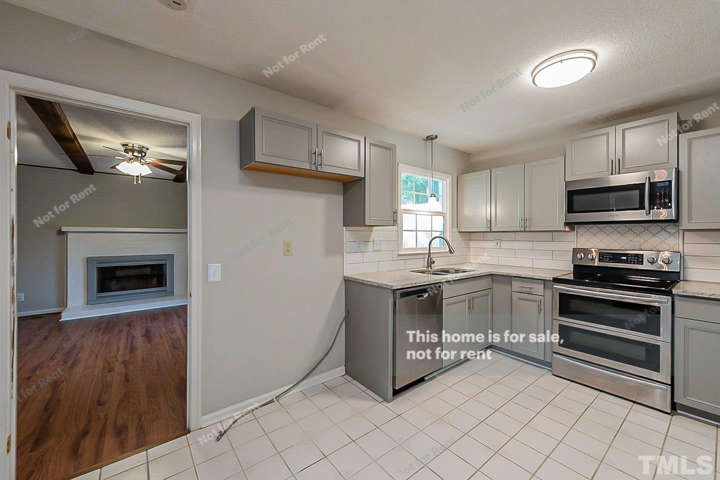 1338 Sedwick Road Durham, NC 27713 - Photo 4 of 20 a kitchen with granite countertop a stove top oven and cabinets