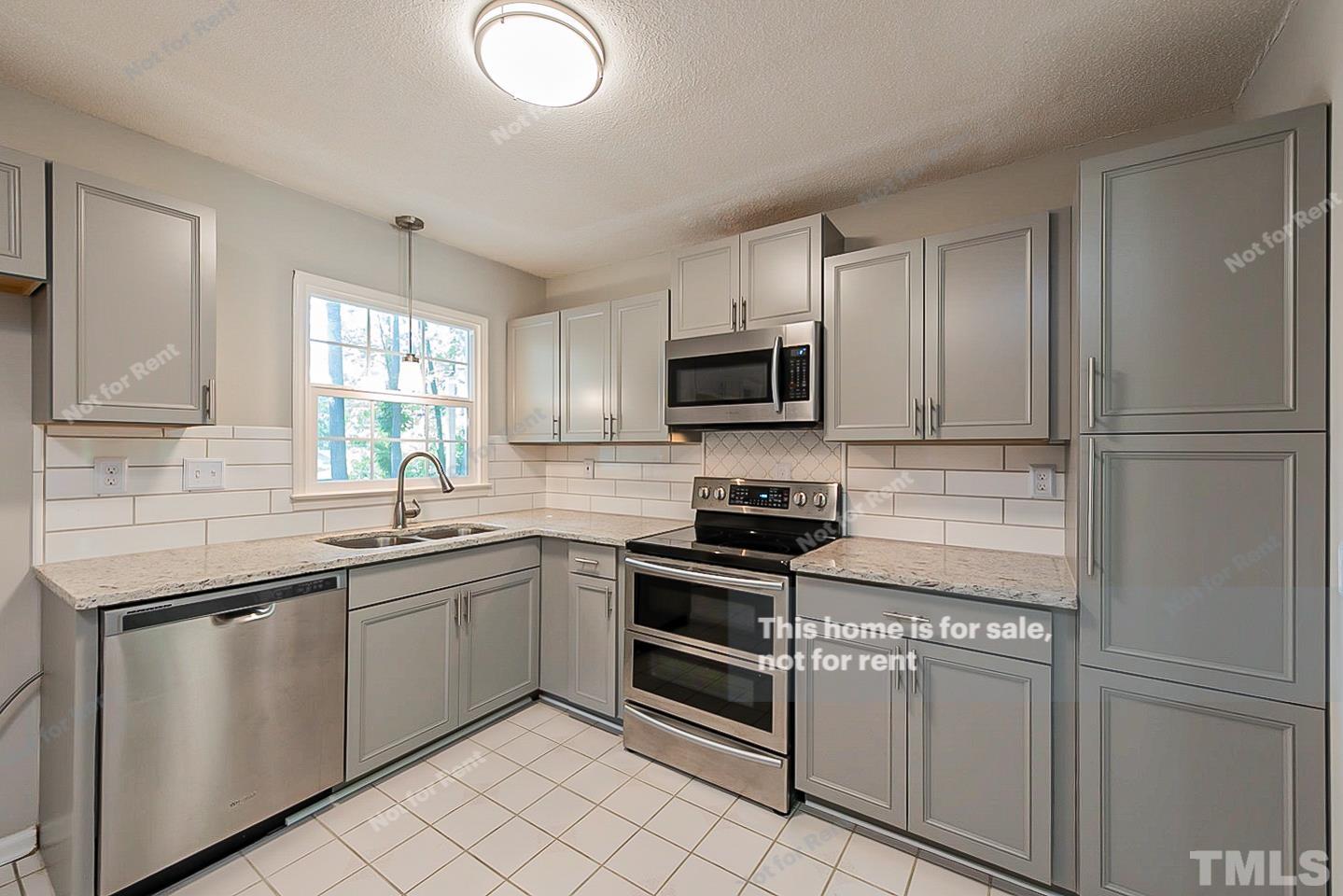 1338 Sedwick Road Durham, NC 27713 - Photo 5 of 20 a kitchen with a sink appliances and cabinets