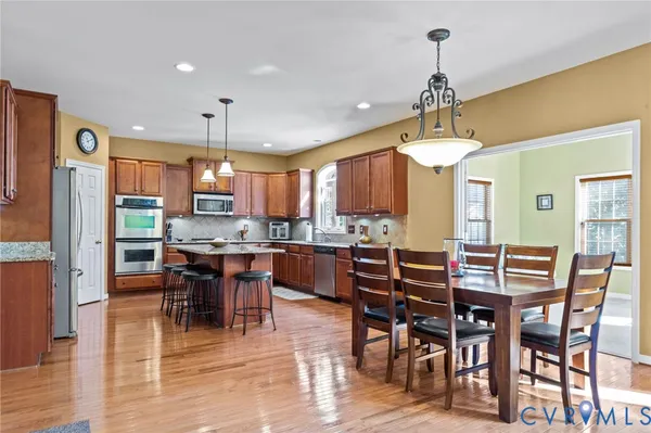 a kitchen with stainless steel appliances granite countertop a refrigerator a oven a sink a stove and a center island