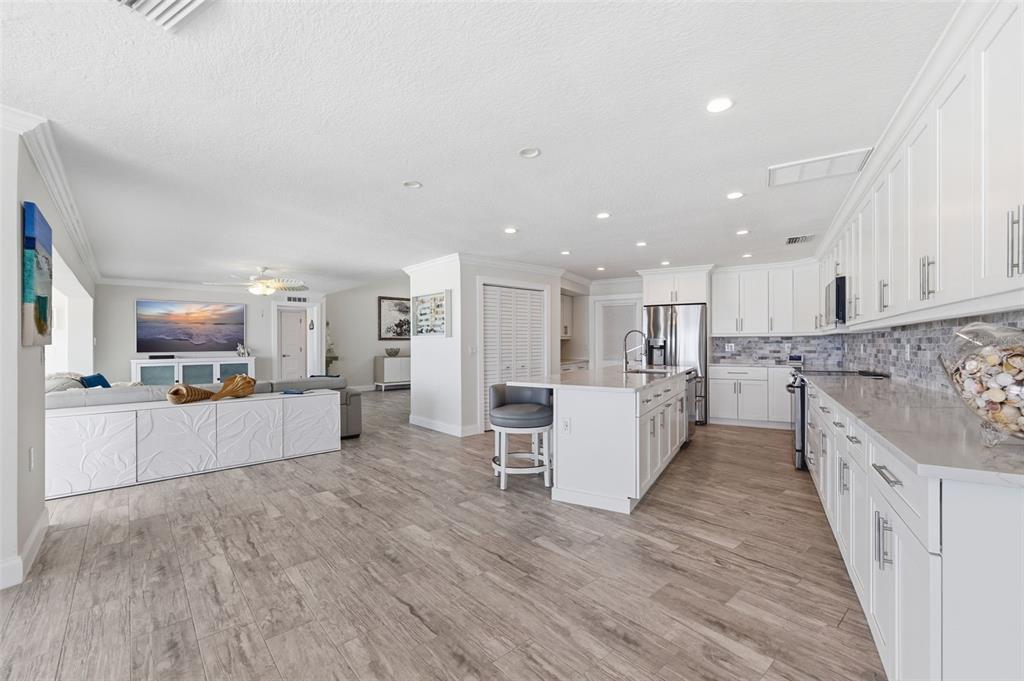 16123 6th Street East Redington Beach, FL 33708 - Photo 13 of 48 a large kitchen with stainless steel appliances kitchen island a large counter top and view living room