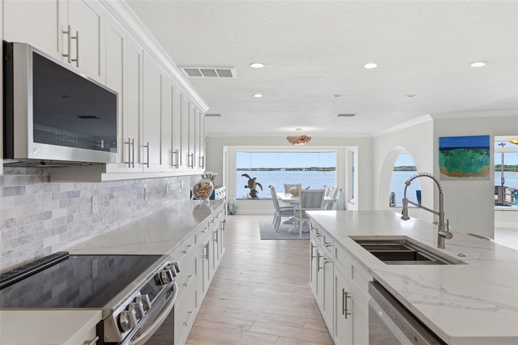 16123 6th Street East Redington Beach, FL 33708 - Photo 14 of 48 a kitchen with stainless steel appliances granite countertop a stove a sink and a microwave