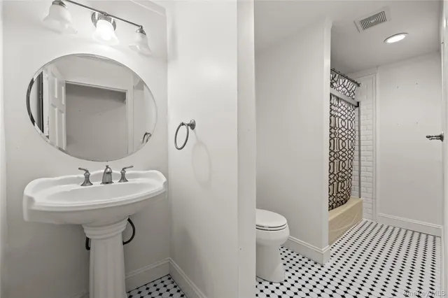 a bathroom with a sink a toilet and a mirror