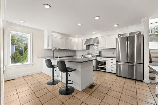 a kitchen with stainless steel appliances granite countertop a stove a sink a refrigerator and a refrigerator