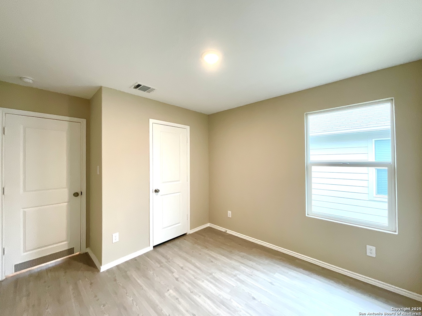 10751 Margarita Loop Converse, TX 78109 - Photo 14 of 40 a view of an empty room with wooden floor and a window