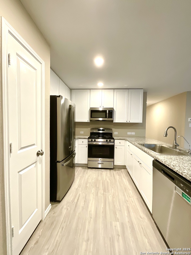 10751 Margarita Loop Converse, TX 78109 - Photo 19 of 40 a kitchen with granite countertop a refrigerator stove and sink