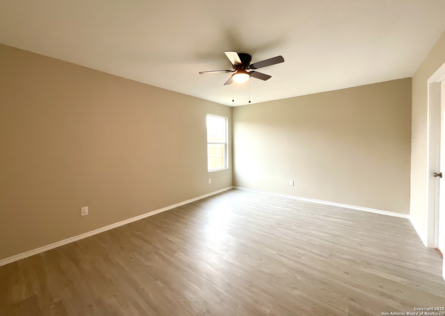 10751 Margarita Loop Converse, TX 78109 - Photo 26 of 40 a view of an empty room with wooden floor and a ceiling fan