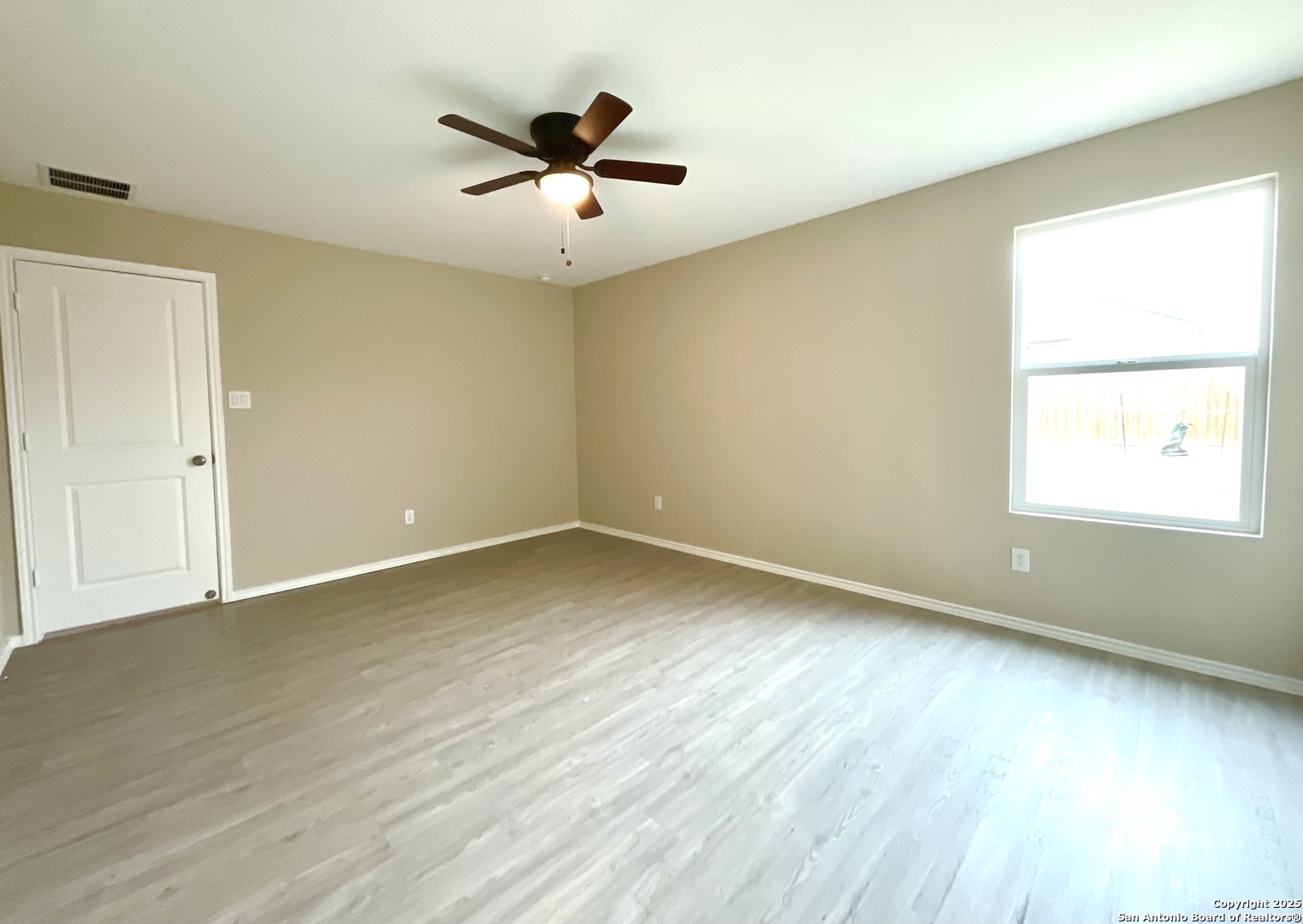 10751 Margarita Loop Converse, TX 78109 - Photo 27 of 40 an empty room with wooden floor and windows
