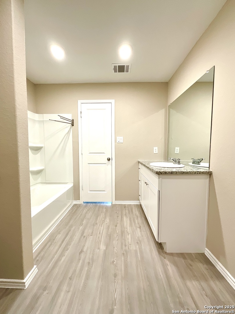 10751 Margarita Loop Converse, TX 78109 - Photo 30 of 40 a bathroom with a sink a mirror and a bathtub