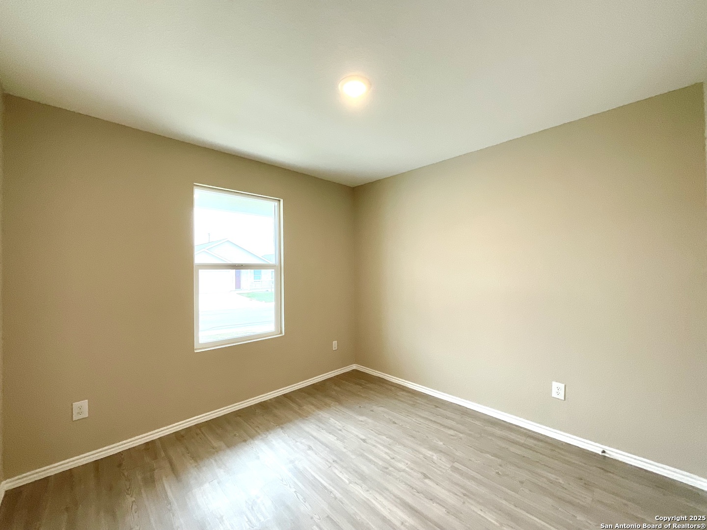 10751 Margarita Loop Converse, TX 78109 - Photo 9 of 40 an empty room with wooden floor and windows