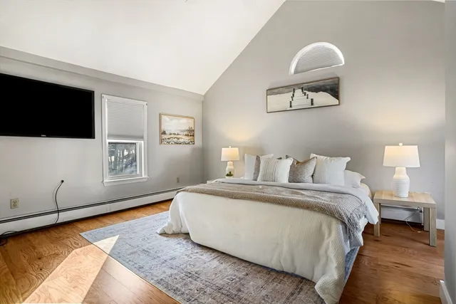 a spacious bedroom with a bed and a flat screen tv