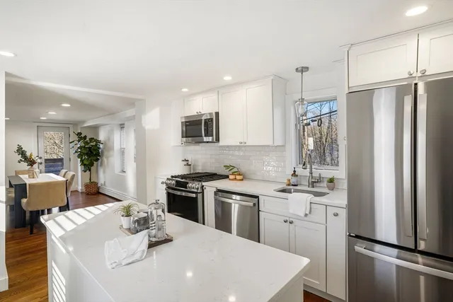 a kitchen with stainless steel appliances a sink stove refrigerator and cabinets