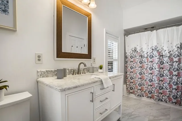 a bathroom with a granite countertop sink a toilet and a mirror