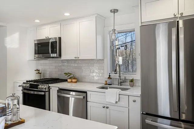 a kitchen with stainless steel appliances granite countertop a refrigerator stove and microwave