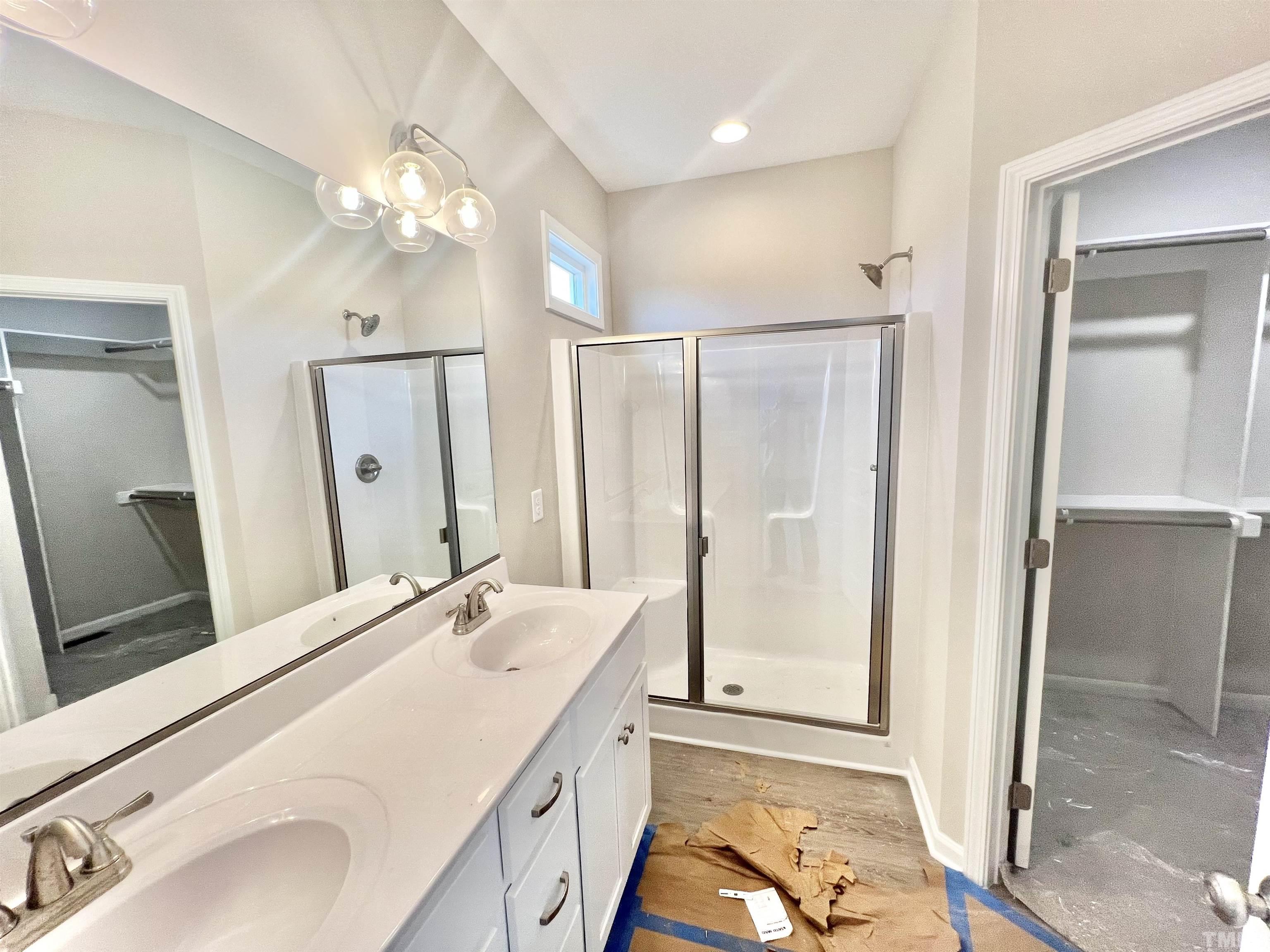 4525 Debnam Road Zebulon, NC 27597 - Photo 8 of 10 a bathroom with a double vanity sink mirror and shower