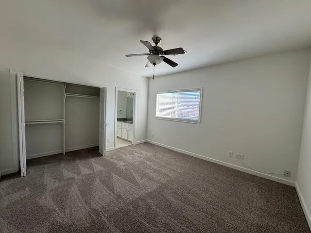 an empty room with windows and fan