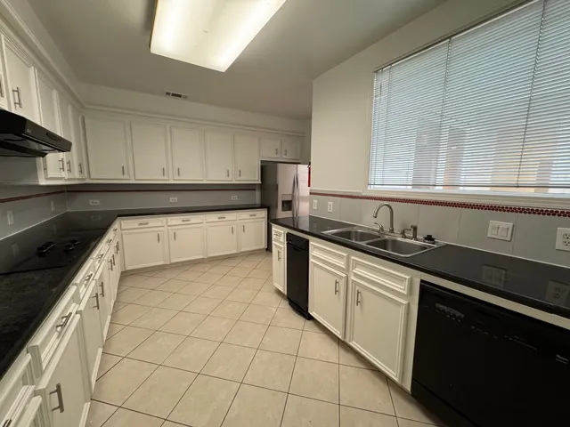 a kitchen with granite countertop a sink a stove and cabinets