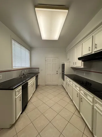 a kitchen with granite countertop a sink and a stove