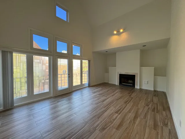 a view of empty room with wooden floor and fireplace