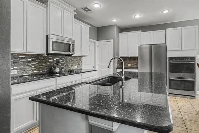 a kitchen with stainless steel appliances granite countertop a sink a microwave and stove