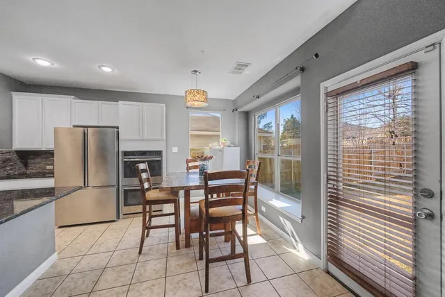 a dining room with furniture and a refrigerator