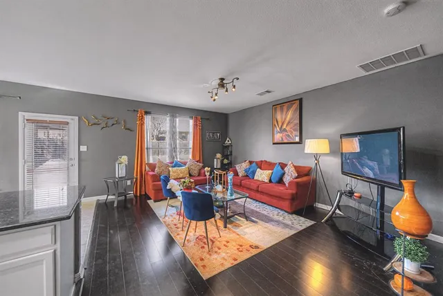 a living room with furniture and a wooden floor