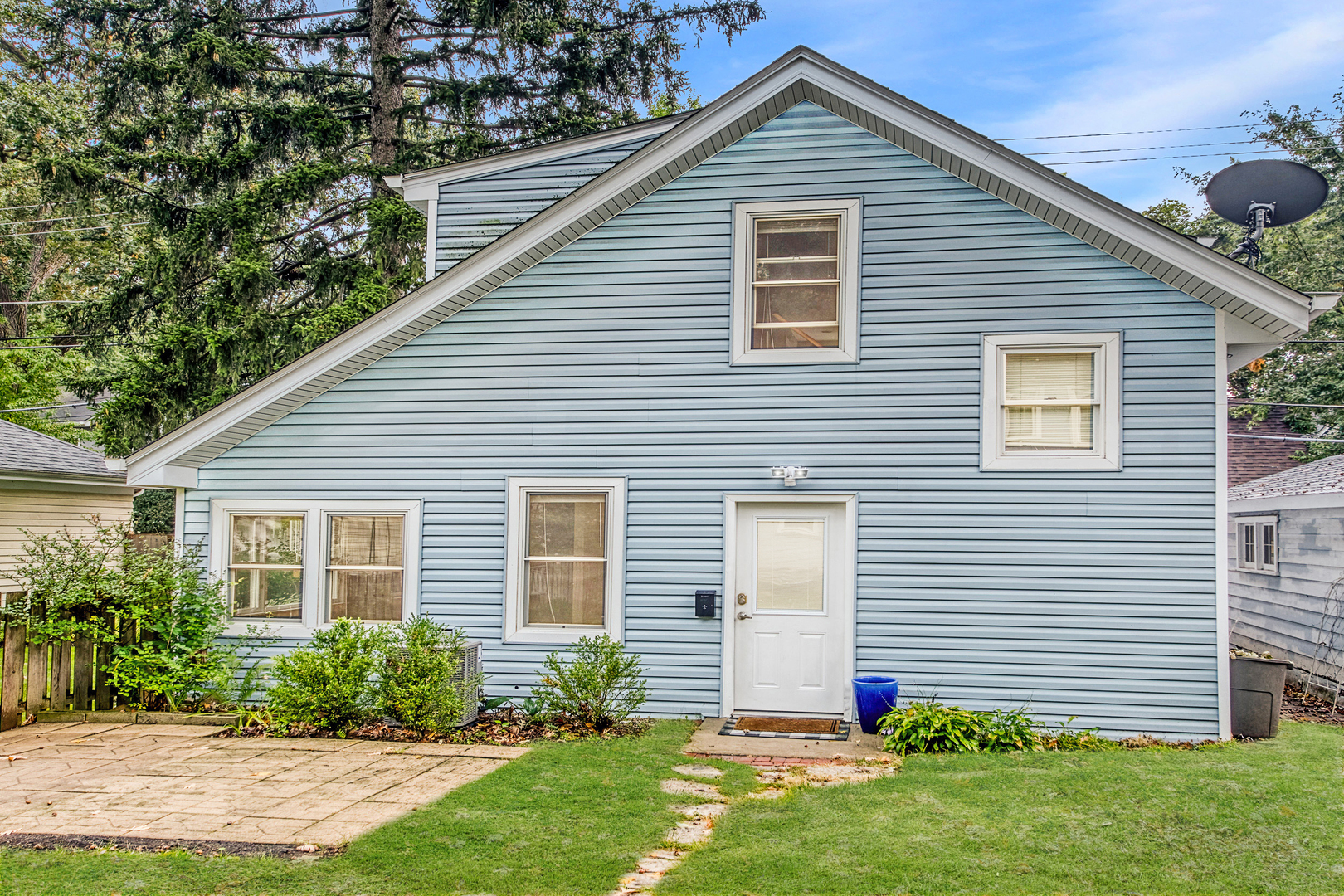 a front view of house with a garden and plants