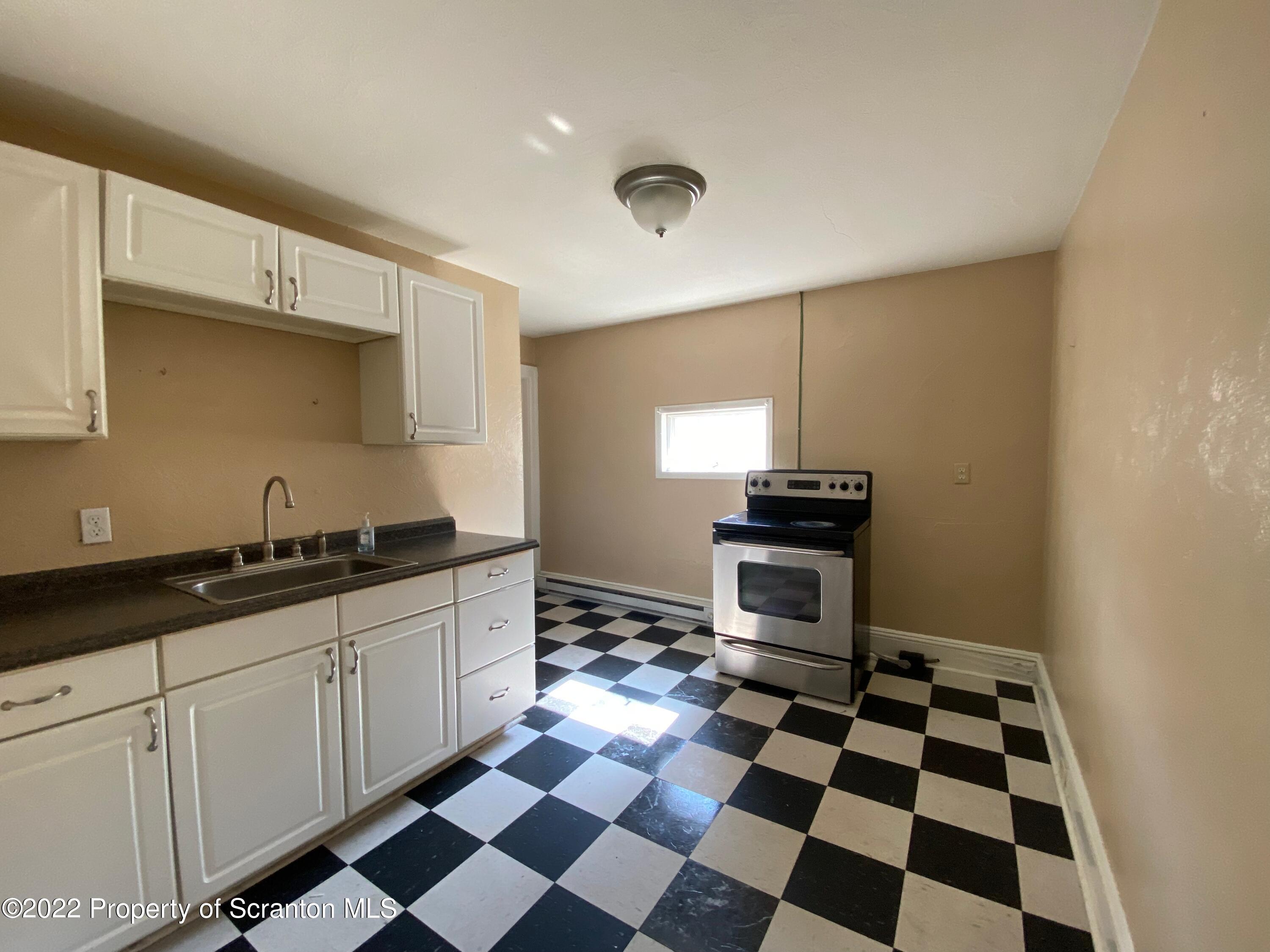 600 Main Street Moosic, PA 18507 - Photo 13 of 19 a kitchen with a checkered floor and white cabinets