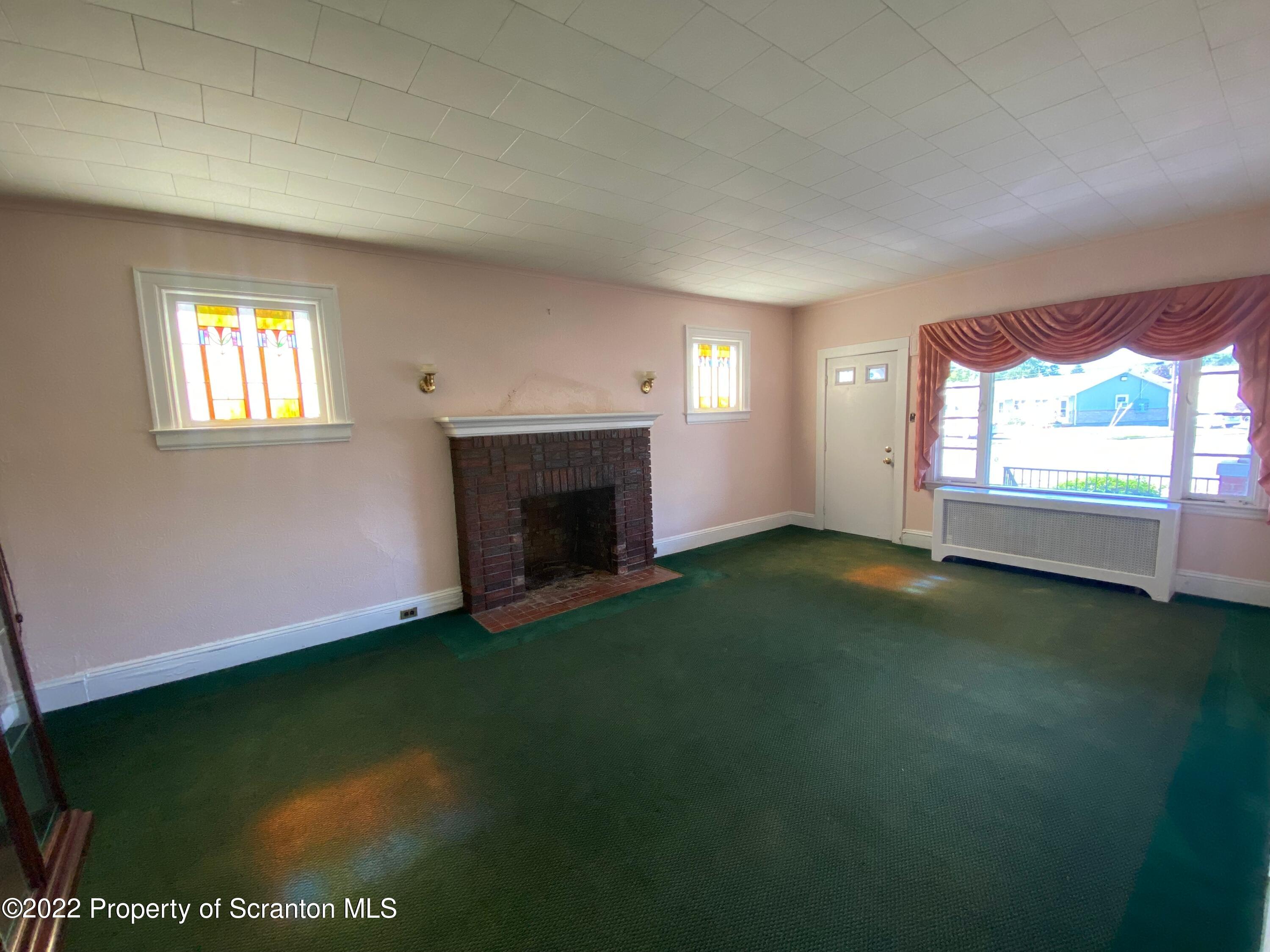 600 Main Street Moosic, PA 18507 - Photo 2 of 19 an empty room with windows and fireplace
