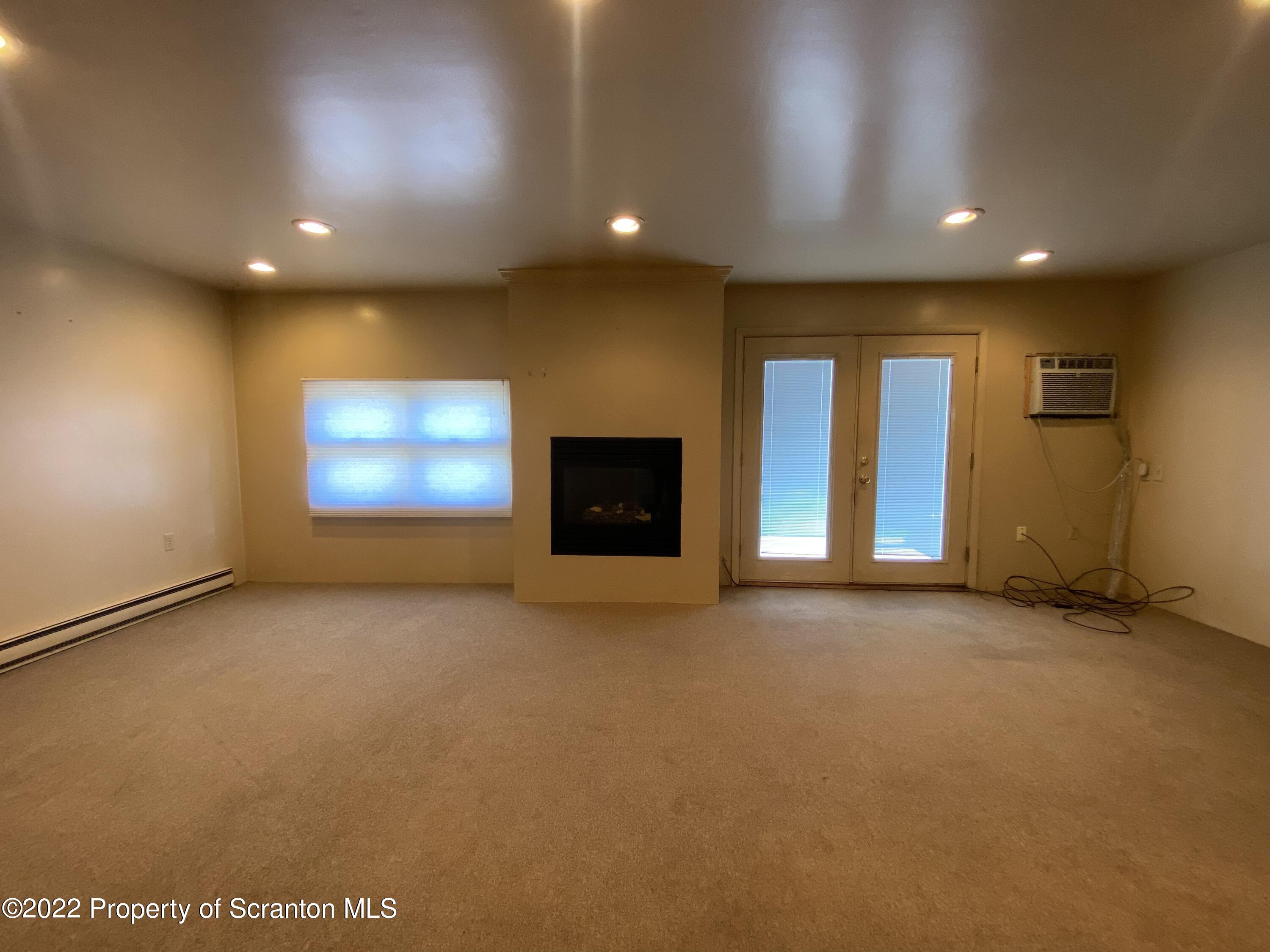 600 Main Street Moosic, PA 18507 - Photo 8 of 19 an empty room with windows and fireplace