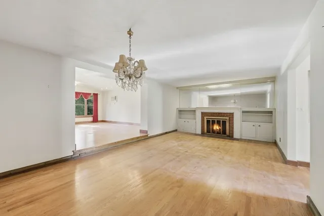 a view of an empty room with a window and a fireplace