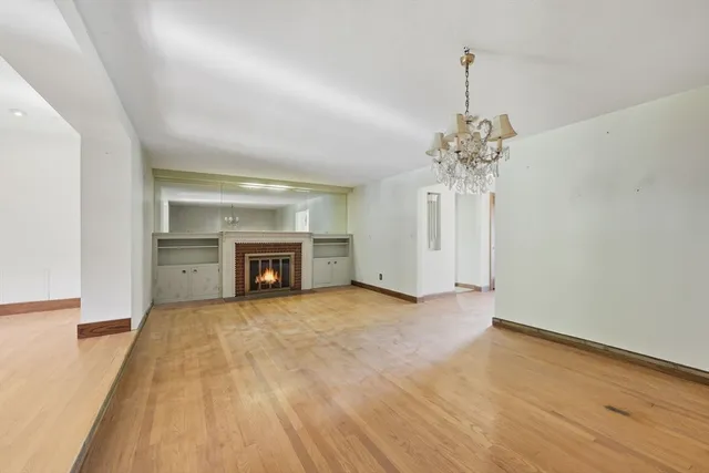 a view of an empty room with a fireplace and a window