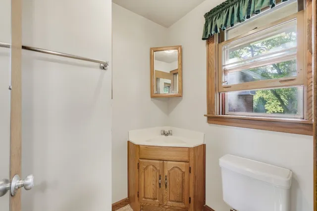 a bathroom with a sink a toilet and a window