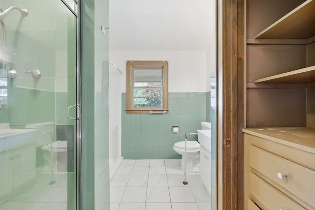 a bathroom with a sink a toilet and shower