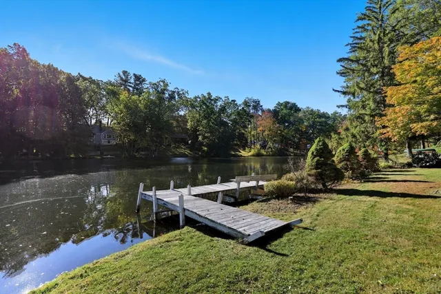 a view of a lake with a bench and a wooden fence