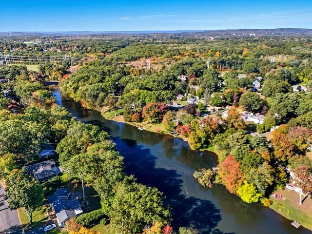 an aerial view of a city with lots of residential buildings ocean and mountain view in back