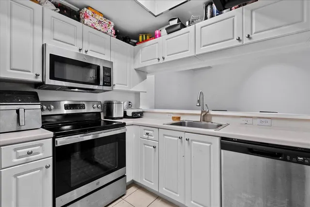 a kitchen with white cabinets and stainless steel appliances