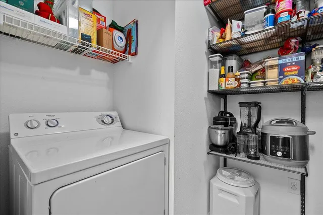 a living room with furniture a flat screen tv and a refrigerator