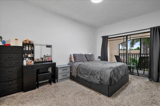 a spacious bedroom with a bed and a refrigerator