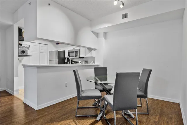 a living room with furniture a flat screen tv and kitchen view
