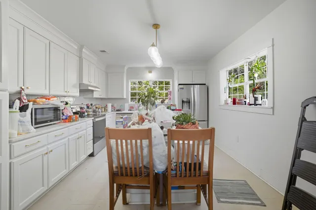 a kitchen with granite countertop white cabinets and stainless steel appliances