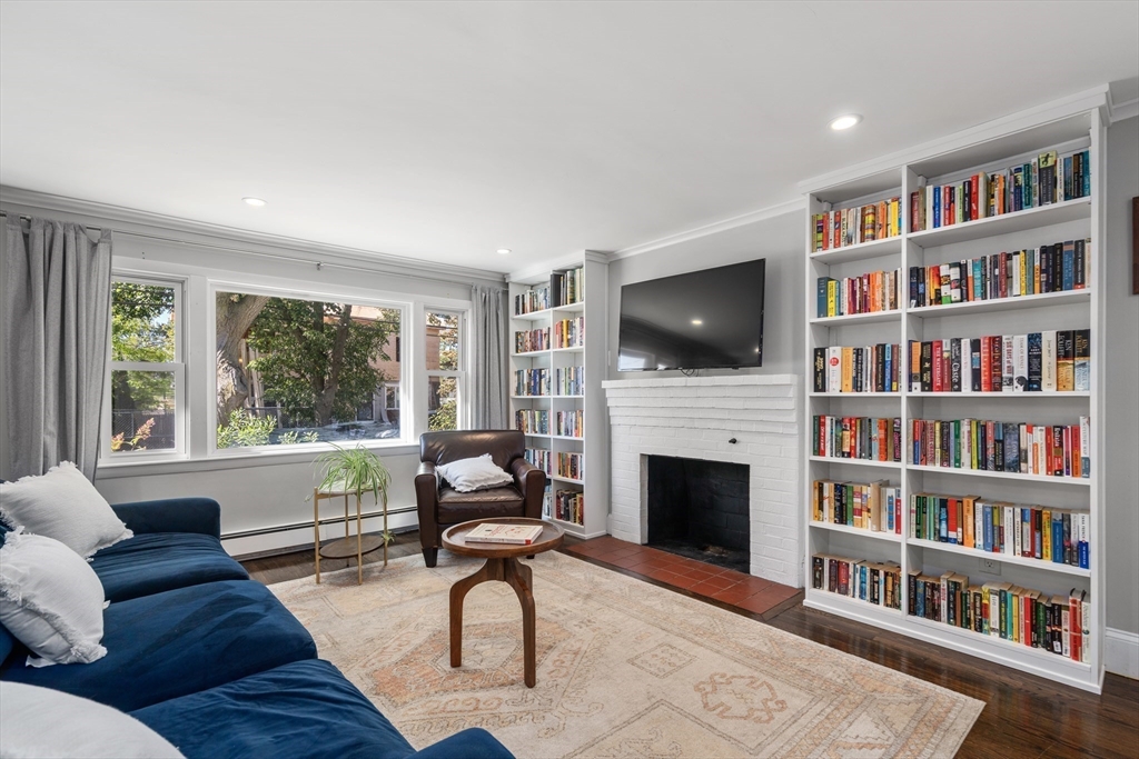 1 Dow Road Boston, MA 02132 - Photo 2 of 28 a living room with fireplace furniture and a book shelf
