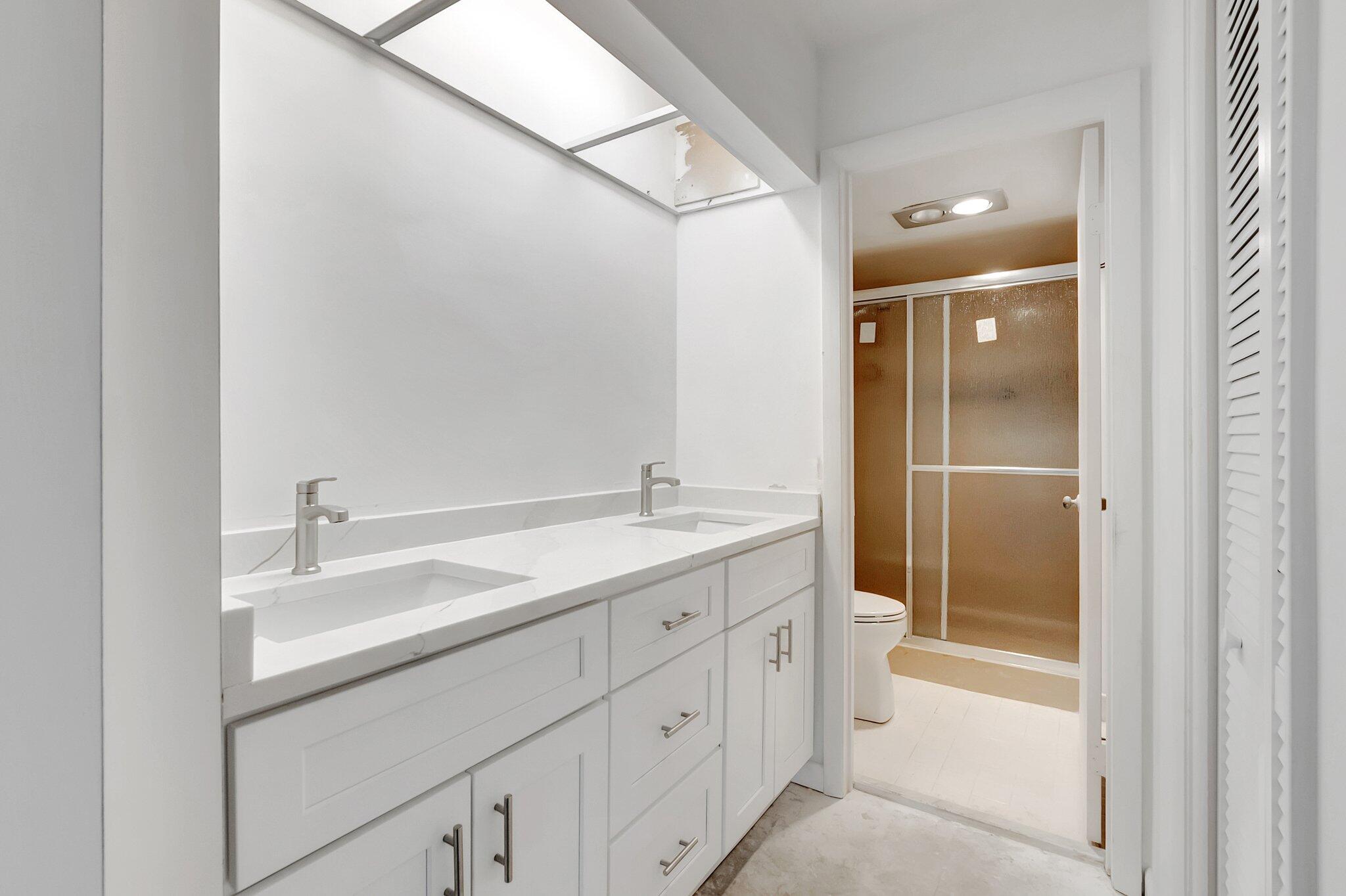 6320 Boca Del Mar Drive, Unit 301 Boca Raton, FL 33433 - Photo 23 of 46 a bathroom with a double vanity sink and mirror with shower