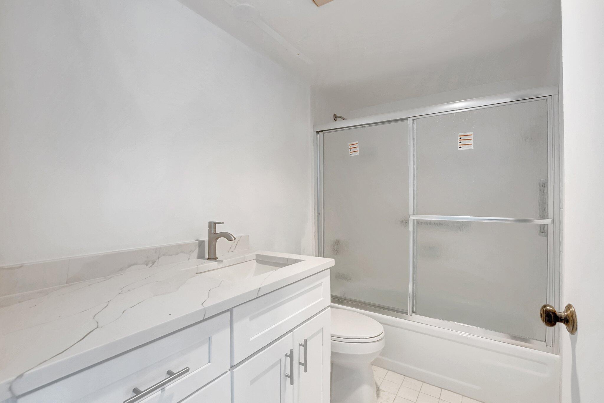 6320 Boca Del Mar Drive, Unit 301 Boca Raton, FL 33433 - Photo 28 of 46 a bathroom with a sink a toilet and shower