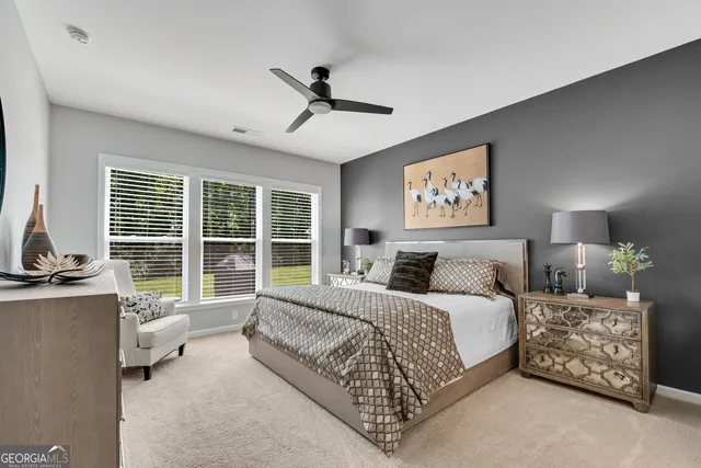 a spacious bedroom with a bed couch and a large window