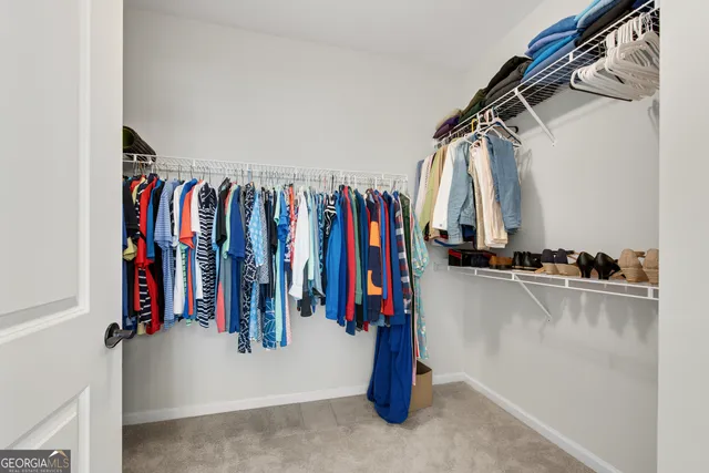 a view of walk in closet with clothes
